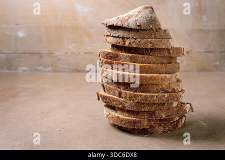 Stack of sliced rye bread with crunchy crust on beige background. Homemade artisan bread perfect for sandwiches breakfast or healthy eating. Stock Photo