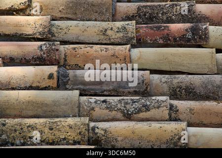 Full frame shot of weathered roof tiles showing grunge texture, moss, and color variations from beige to dark grey, typical of old Greek architecture Stock Photo