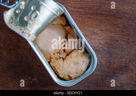 Open tin can with cod liver on wooden table background, close up, top view, copy space Stock Photo
