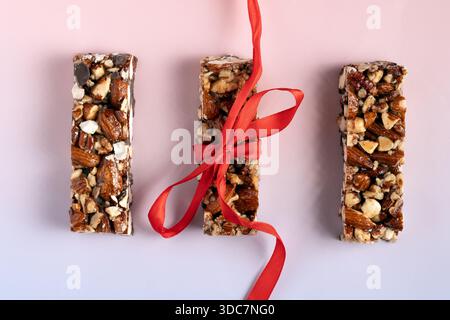 Homemade crunchy cereal bars wrapped in paper and blue string rest on a ...