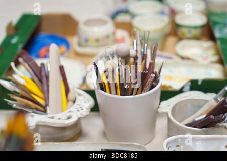 Various professional art brushes of different shapes and sizes in containers on a studio table. High quality photo Stock Photo