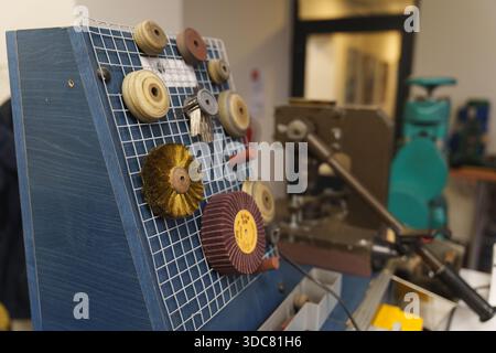Various professional jewelry polishing wheels and abrasive discs on a workshop tool rack. High quality photo Stock Photo
