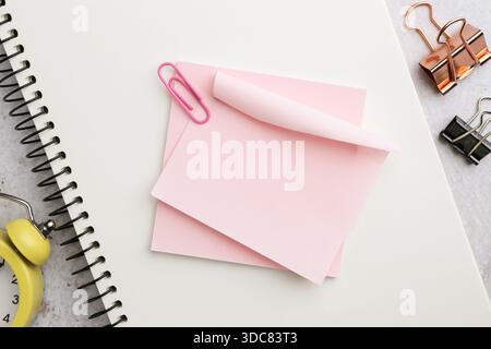 Blank notes, notebook, binder clips and alarm clock on table, flat lay Stock Photo