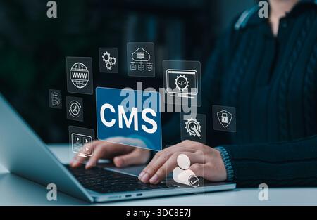 Woman working on laptop with CMS - Content Management System interface icons, representing website management, coding, cloud technology, workflow tool Stock Photo