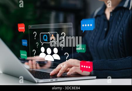 Online Q&A and customer support concept. Woman using laptop with virtual chat bubbles, question marks, and people icons symbolizing communication, FAQ Stock Photo