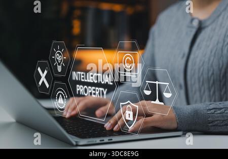 Intellectual property protection concept. Woman working on laptop with copyright, patent, security, and legal icons representing digital rights, trade Stock Photo