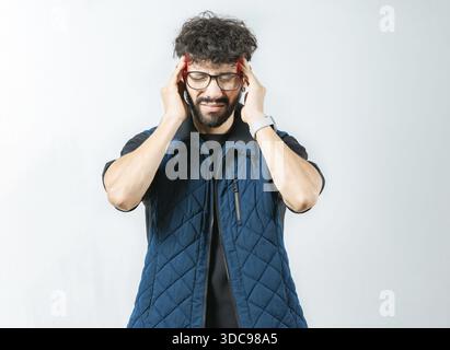 Unhappy person with a headache and isolated migraine isolated. Man with a severe migraine holding head Stock Photo