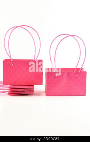 Fuchsia plastic flower gift bags with long loop handles on a white background, featuring a rectangular shape ideal for bouquet packaging, decor, and g Stock Photo