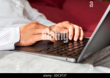 Remote work from home using a laptop on a couch Stock Photo