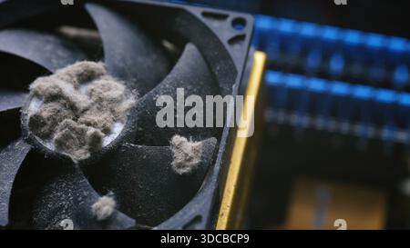 Close-up shot showing mounds of thick dust clogging a PC cooling fan. Stock Photo