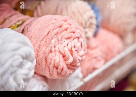 Soft pink and white yarn rolls in basket displaying cozy texture for knitting and crafting projects. Stock Photo