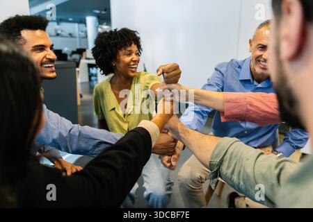 Diverse business team stacking fists showing unity Stock Photo