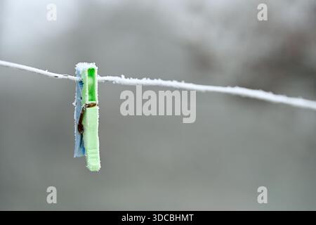 Frost on plastic clothes peg left on a washing line in winter Stock Photo
