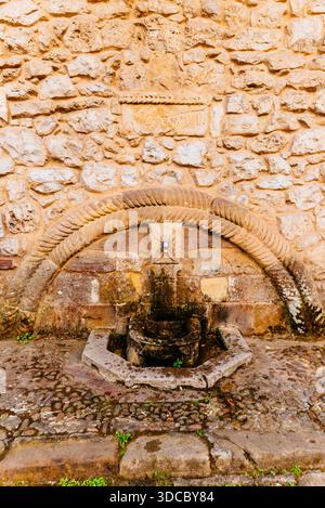 Fountain attached to the wall in the Plaza Mayor - Main Square. It is a stone fountain in the Baroque style from the 17th century, whose decoration co Stock Photo