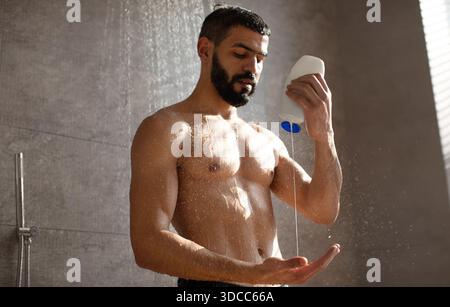 Confident Young Man Washing Hair With Shampoo in a Home Shower Stock Photo