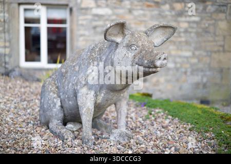 Yorkshire Dales, UK - September 16, 2024. Decorative stone pig sculpture in a front garden outside a stone cottage in Grassington, Yorkshire Stock Photo