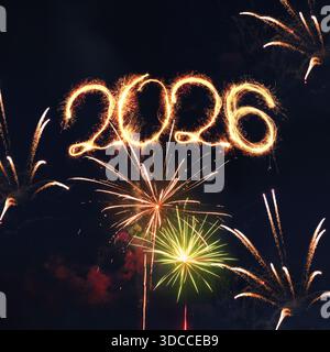 Happy New Year 2026 Firework Display in Night Sky. Golden sparklers forming the number 2026 against a dark sky with colorful fireworks. vibrant celebr Stock Photo