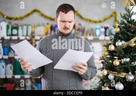 Thoughtful owner of home essentials store examining documents Stock Photo
