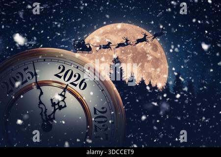 Magical holiday time transition to 2026. A snowy, New Year's Eve clock is set against a massive full moon with Santa Claus and his reindeer flying acr Stock Photo