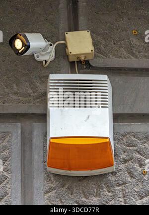 Video surveillance signal alarm with cameras for motion detection hanging on a building facade wall Stock Photo