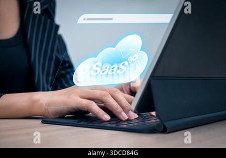 SaaS technology concept showing female hands using cloud-based software service via tablet. Software as a Service for business operations, digital tra Stock Photo