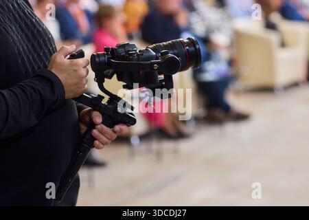 Closeup image showing someone gripping a DSLR camera with an articulated screen Stock Photo