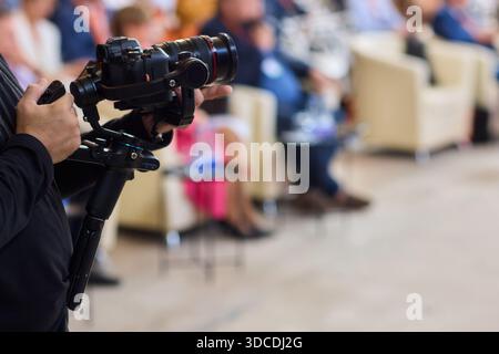 Closeup image showing someone gripping a DSLR camera with an articulated screen Stock Photo