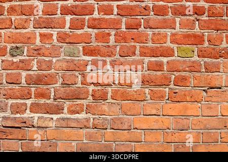 Old red brick wall texture with natural imperfections and weathered surface. Rustic brick background suitable for architecture, construction, design p Stock Photo