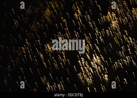 Abstract blurred golden glittering light on the black background Stock Photo