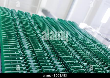 Rows of blank green printed circuit boards standing in rack in clean modern electronics factory forming abstract technology background Stock Photo