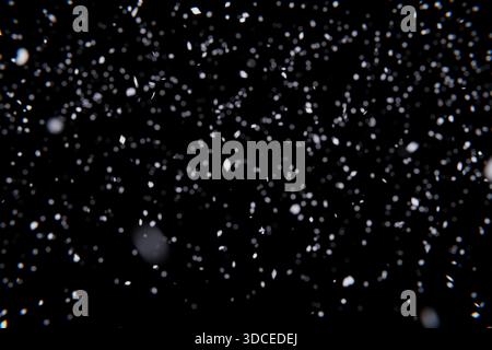 Realistic Snowfall on Black. Dynamic winter scene with crisp, tiny snowflakes and soft blur. Use as an isolated background for Christmas, weather, or Stock Photo