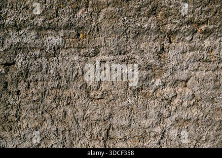 Cement-coated old brick wall showing underlying brick pattern and weathered surface texture. Worn rustic background. Stock Photo