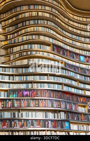 View of a mesmerizing, undulating wall of books creating a vibrant, colorful, and textured pattern, Chongqing, Chongqing, China. Stock Photo