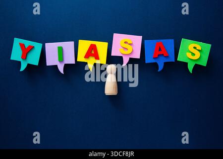 Wooden person figure surrounded by colorful speech bubbles with yiasas text Stock Photo