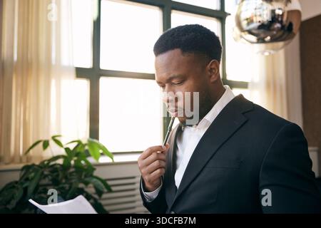 Concentrated male lawyer examining document in office Stock Photo