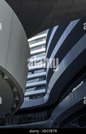 View of curved buildings with striking lines create a modern cityscape, contrasting with the sky in the background, Beijing, China. Stock Photo