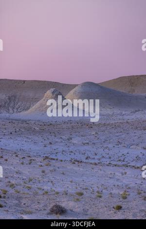 View of the desert landscape with pastel-colored mounds under a soft purple sky, ground photo, Senek, Mangystau Region, Kazakhstan. Stock Photo