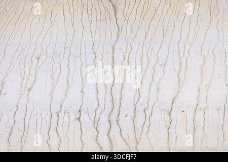 View of parched earth displaying intricate erosion patterns that carve delicate rivulets into the pale landscape, a testament to time's patient hand, Stock Photo