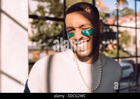 Sunlight shining on smiling man with under-eye patch winking at camera Stock Photo