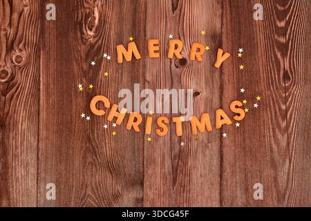 Merry Christmas cookies and festive stars on dark wooden background. Top view, copy space. Christmas Baking background. Stock Photo