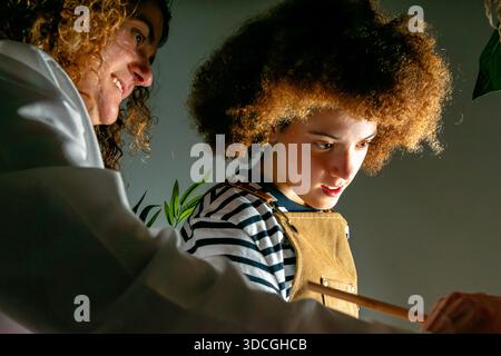 Mentor and young creative engaging in concentrated hands-on learning, showing guidance Stock Photo