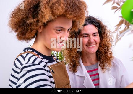 Two smiling women collaborating on a task, expressing happiness and teamwork Stock Photo