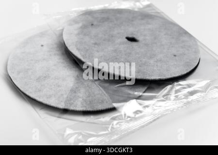 Packaged round industrial filtration discs in transparent plastic. Clean water system components. Household maintenance supplies Stock Photo