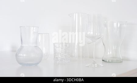 A minimalist still life featuring transparent glassware arranged on a white surface in a bright high key interior. This image is suitable for modern i Stock Photo
