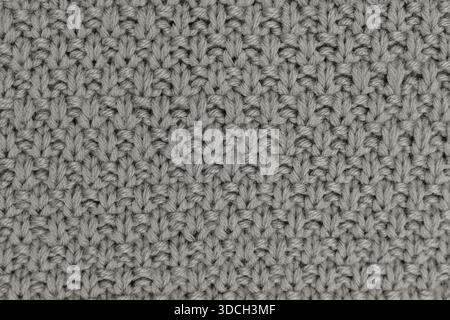 Close-up of gray knitted fabric texture with visible stitches and yarn pattern Stock Photo