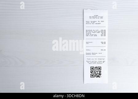 Paper receipt with qr code on white desk, expense documentation concept with copy space for digital payment, accounting, auditing, and expense managem Stock Photo