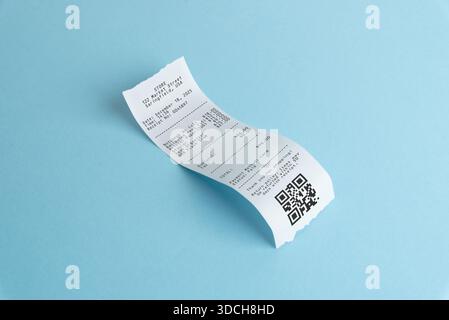 Curved paper receipt with qr code on blue background, representing digital payments, expense scanning, accounting workflow, and modern receipt managem Stock Photo