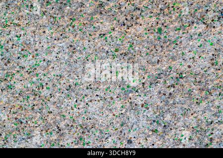 High angle view of a concrete surface with embedded colorful crushed glass pieces. Stock Photo