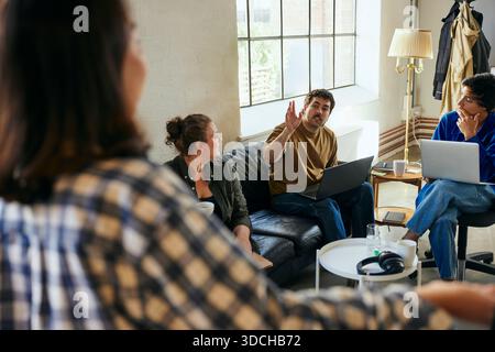 Male business expert asking question during meeting with colleagues in tech office Stock Photo