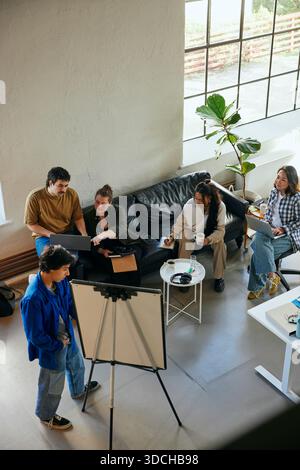 High angle view of male and female business experts discussing with each other while sitting in startup office Stock Photo